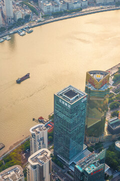 The Citi Bank and Aurora Plaza headoffice towers under a golden sunset over Pudong with a cargo boat gliding along the the Huangpu River, Shanghai, China, 31 July 2026