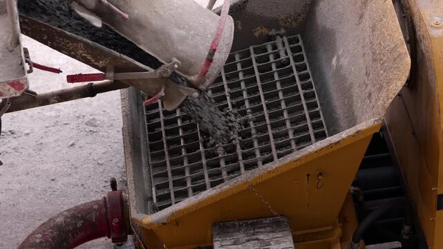 Fresh concrete discharged from mixer into receiving hopper