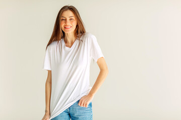 Obraz premium Smiling young woman in a white t shirt in a wide frame