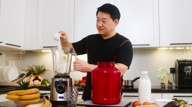 Asian young man pours whey protein into blender with banana and cottage cheese for breakfast shake. Protein smoothie supports muscle weight control fitness energy and clean home diet plan daily good.