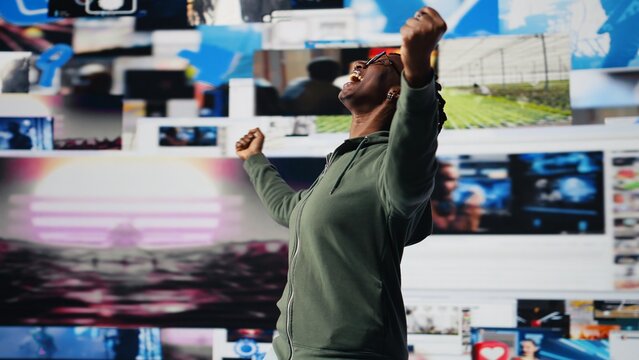 Cheerful user watching internet video channels on videowall