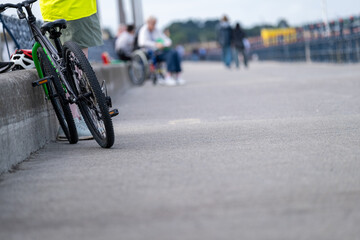 Naklejka premium Bicycle and wheelchair user sharing an accessible urban waterfront promenade