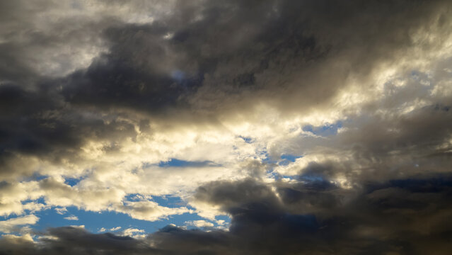 bright sun rays breaking through heavy cumulus clouds in sky