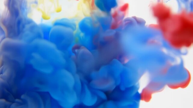 Vivid blue, red, and yellow ink plumes swirl in a white space, creating dynamic abstract forms