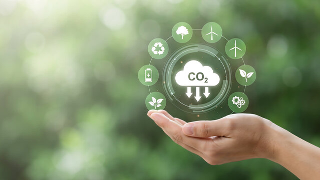 Hand holding holographic display showing carbon dioxide reduction with eco icons