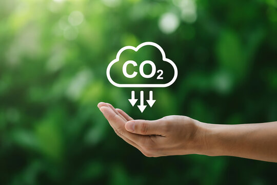 Hand releasing co2 emissions into a green nature background