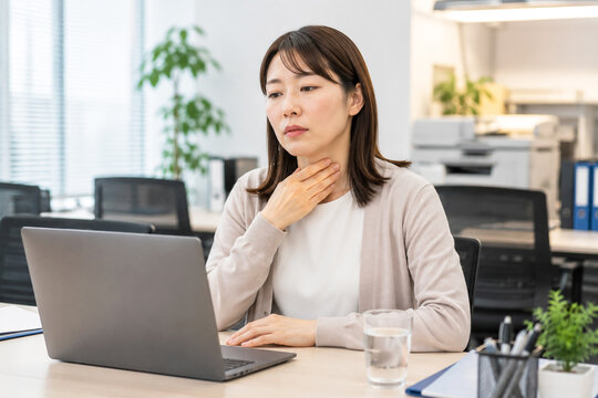 オフィスで喉の痛みを訴える女性