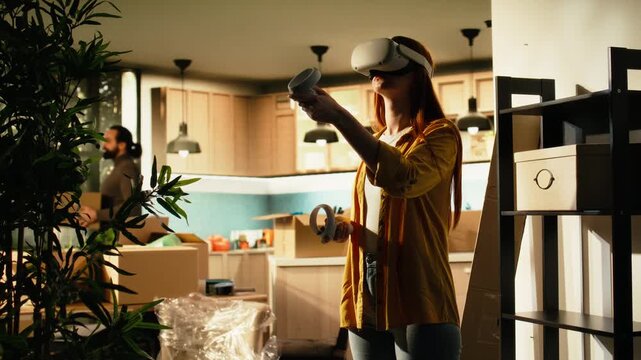 Woman in VR glasses planning an interior layout for a new residential property, using a virtual floor plan to arrange furniture while preparing for relocation and a fresh start as a homeowner indoors.