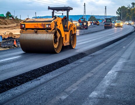 A heavy yellow road roller flattening fresh dark asphalt on a highway construction site. Ideal for civil engineering, infrastructure development, and industrial project concepts.