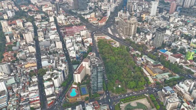 High-angle aerial hyperlapse overlooking 23-9 Park, busy, dense city traffic around Quach Thi Trang roundabout and modern skyscrapers in central District 1, Ho Chi Minh City, Vietnam
