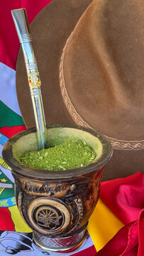 Chimarr&atilde;o, hat, and gaucho neckerchief resting on the flag of the State of Rio Grande do Sul, Brazil. Farroupilha Week. Gaucho Day.