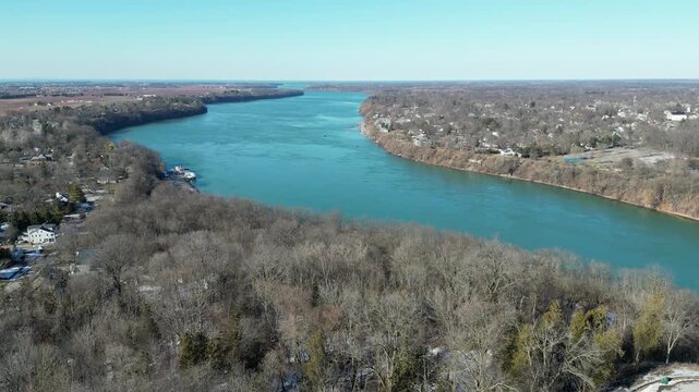 Aerial of Niagara River towards Lake Ontario during winter, March 2023. Border of United States and Canada, at Queenston, Ontario and Lewiston, New York. Flying forward, north during late winter.