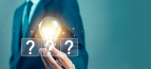 Creative business concept featuring a glowing light bulb held by a professional, symbolizing innovation, ideas, problem solving, creativity, opportunity, strategy, inspiration, and decision making. © wanchai peatoo