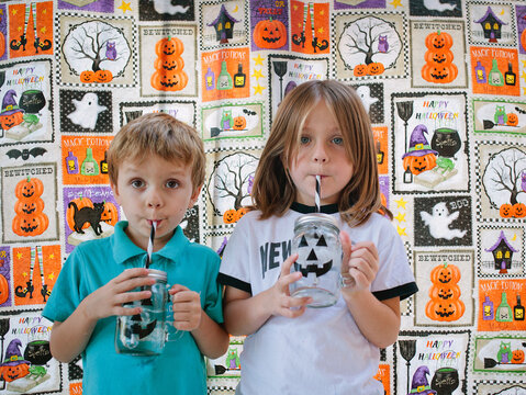 Two Kids in Front of Halloween Themed Wall