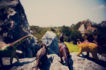 Dinosaur figure toy on the top of mountain © Rawpixel.com