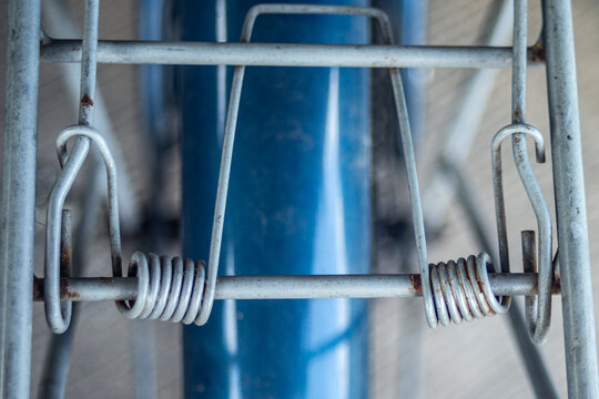 Close up of vintage bicycle rear rack with steel spring clip mechanism.A detailed top-down shot focusing on the spring-loaded cargo clip mechanism of a vintage bicycle rear carrier rack. 