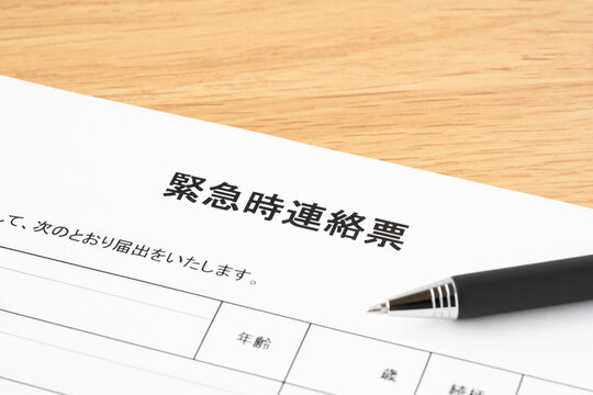 緊急時連絡票と黒いボールペンのクローズアップ