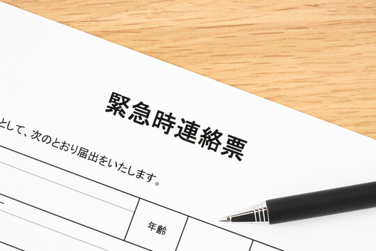 緊急時連絡票と黒いボールペンのクローズアップ