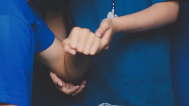 Doctor physiotherapist assisting a male patient while giving exercising treatment massaging the arm of patient in a physio room, rehabilitation physiotherapy concept