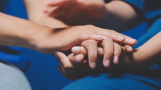 Doctor holding patient's hand on a white desk during medical consultation, offering support, empathy, care, reassurance, and compassion in a hospital or clinic setting