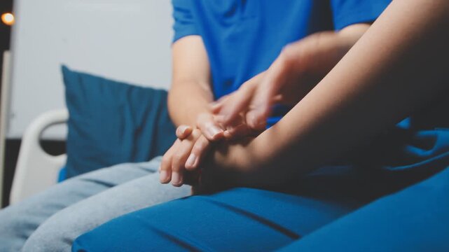 Doctor holding patient's hand on a white desk during medical consultation, offering support, empathy, care, reassurance, and compassion in a hospital or clinic setting