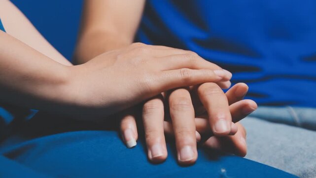 Doctor holding patient's hand on a white desk during medical consultation, offering support, empathy, care, reassurance, and compassion in a hospital or clinic setting
