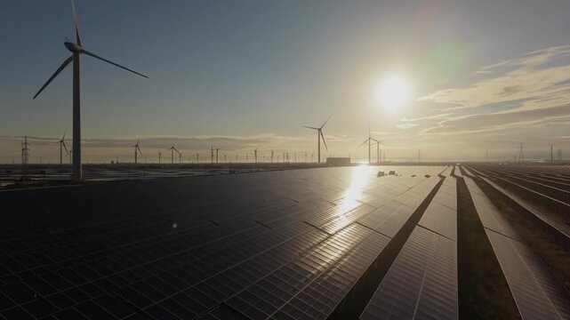 Solar and Wind Energy Farm at Sunrise or Sunset