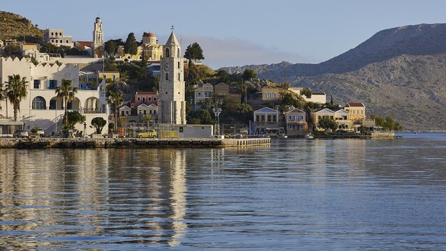 Coastal town with a tower, church, mountains in the background, calm water, Symi town, Symi, Dodecanese, Greek Islands, Greece
