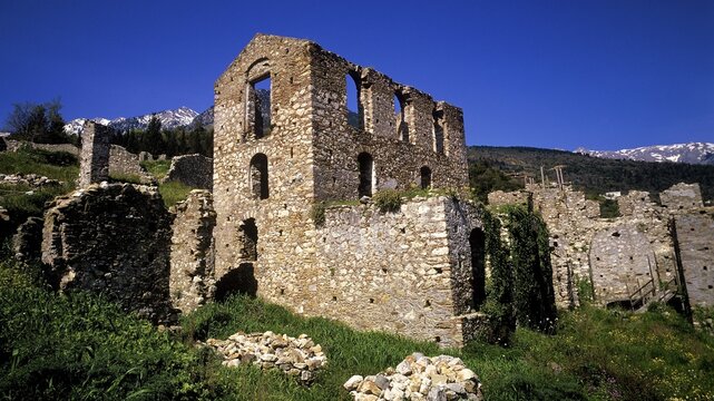Stone ruins of an abandoned building with mountains in the background under a clear sky, Mystras, Mistra, UNESCO World Heritage Site, Medieval Byzantine ruined city, northwest of Sparta, foothills of the Tyagetos Mountains, Peloponnese, peninsula, Greece