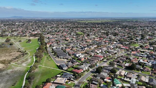 Aerial view of dense residential housing bordered by Heathdale Glen Orden Wetlands parklands and walking trails in Werribee, Melbourne, Victoria, Australia. Established suburban rooflines, cul-de-sacs