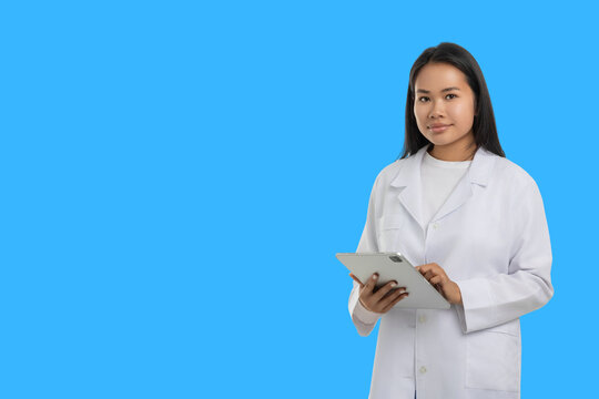 Woman in medical outfit stands with a tablet in her hands