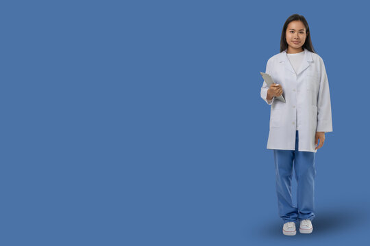 Medical worker stands holding a clipboard in a blue area