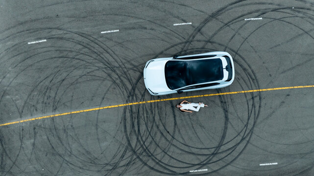 Top view of white ev car.
New ev car on tire marks.
Fast ev car parked on road.
