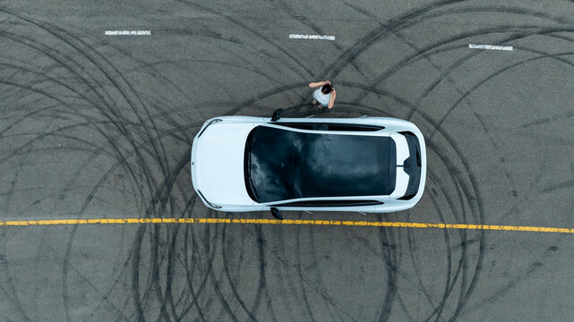 Top view of white ev car.
New ev car on tire marks.
Fast ev car parked on road.