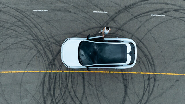 Top view of white ev car.
New ev car on tire marks.
Fast ev car parked on road.