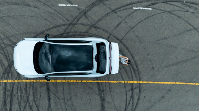 Top view of white ev car.
New ev car on tire marks.
Fast ev car parked on road.