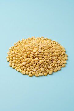 Generated ai Golden Split Mung Beans Pile Displayed on Clean Cyan Background for Healthy Culinary Design