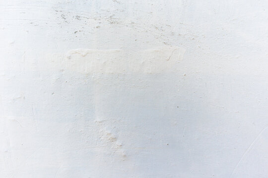 White uneven cement wall textured as background. Retro old plaster sand grungy worn rough whitewashed surface. closeup view. Minimalist coarse concrete texture backdrop with copy space.  