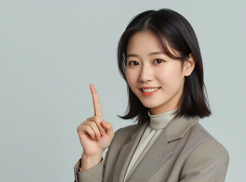 指差しで案内する笑顔のアジア人ビジネスウーマン AI generated｜スーツ姿の女性・説明・ガイド・ビジネスイメージ