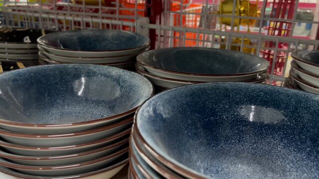 Stack of blue ceramic speckled plates on display in a retail store