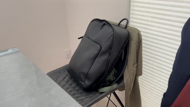 ビジネス用の通勤鞄のファスナーを閉めるビジネスマン