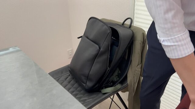 通勤カバンに荷物を入れる男性