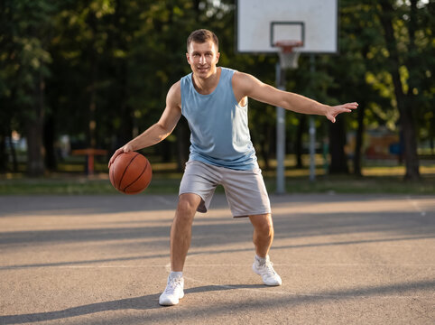 Basketball player dribbling on outdoor court