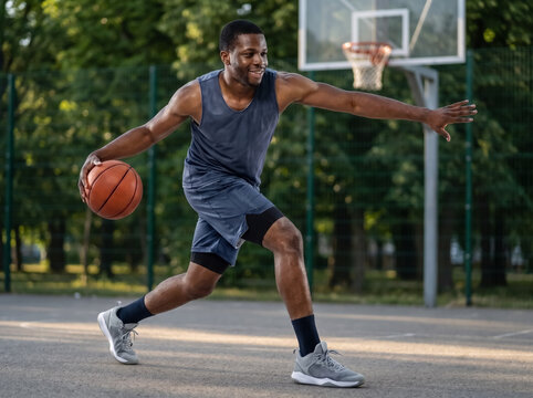 Basketball player dribbling on outdoor court
