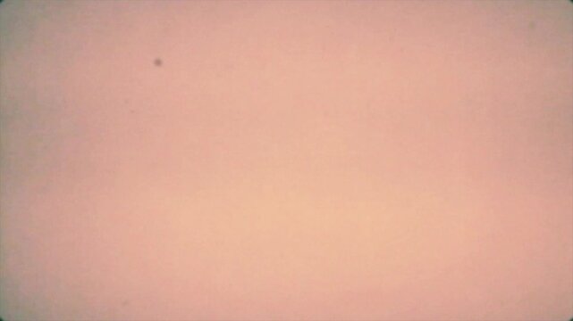 Vintage film texture overlay with light leaks, subtle grain, dust specks, and vignette, soft pink and yellow gradient, perfect for nostalgic backgrounds