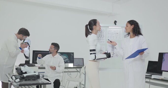 Engineers presenting and testing robotic arm at technical drawing board in white robotics lab