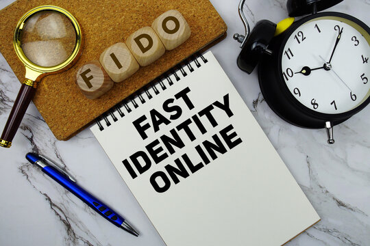 FIDO Fast IDentity Online text written on notepad with calculator and magnifying glass on marble background
