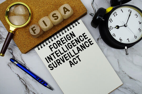 FISA Foreign Intelligence Surveillance Act text written on notepad with calculator and magnifying glass on marble background