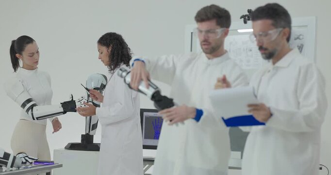 Engineers presenting and testing robotic arm at technical drawing board in white robotics lab