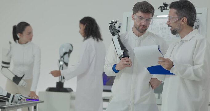 Engineers presenting and testing robotic arm at technical drawing board in white robotics lab